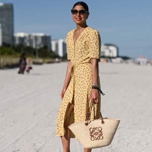 MIAMI, FLORIDA - DECEMBER 01: Sana Rezwan is seen wearing a yellow Rouge dress, Loewe bag and Hermes flats outside UNTITLED Art on December 01, 2021 in Miami, Florida.