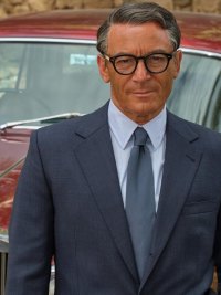 A man stands in front of a car in Archie.