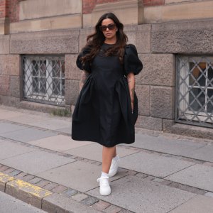 COPENHAGEN, DENMARK - AUGUST 10: Naomi Anwer seen wearing black sunglasses, black short dress, white socks and Copenhagen Studios CPH1 Vitello Off White leather sneaker, on August 10, 2023 in Copenhagen, Denmark. (Photo by Jeremy Moeller/Getty Images for The Wants Social / Copenhagen Studios)