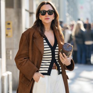 PARIS, FRANCE - MARCH 05: Yasemin Ögün wears brown suede jacket, Louis Vuitton bag, striped black white cardigan, creme white pants, sunglasses outside Courrèges during the Womenswear Fall/Winter 2025/2026 as part of Paris Fashion Week on March 05, 2025 in Paris, France. (Photo by Christian Vierig/Getty Images)