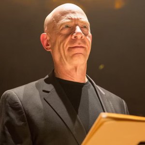 A man stands in front of a lectern in Whiplash.