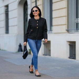 PARIS, FRANCE - JANUARY 07: Patricia Gloria Conteras wears black and white sunglasses, silver Chanel earrings, a pearl necklace, a black jacket with gold buttons, blue denim jeans / pants, a black leather bag, black leather ballerinas shoes, during a street style fashion photo session, on January 07, 2025 in Paris, France. (Photo by Edward Berthelot/Getty Images)