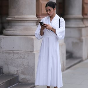LONDON, ENGLAND - SEPTEMBER 18: Ambika Dhir was seen wearing black leather ballerinas, a black bag, a yellow gold and black Yve Saint Laurent bracelet as well as a white dress with collar before Emilia Wickstead Fashion Show during London Fashion Week September 2023 at the on September 18, 2023 in London, England. (Photo by Jeremy Moeller/Getty Images)