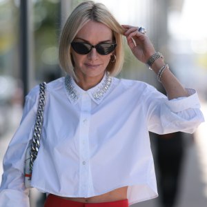 MIAMI, FLORIDA - DECEMBER 07: Lena Johnson seen wearing black sunglasses, silver earrings, white cotton cropped shirt / blouse with rhinestones pattern collar, red long pants and silver watch, on December 07, 2023 in Miami, Florida. (Photo by Jeremy Moeller/Getty Images)