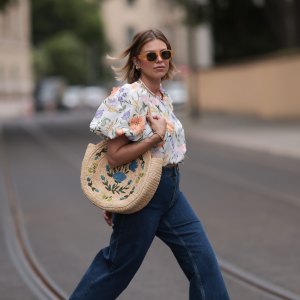 BERLIN, GERMANY - JUNE 06: Aline Kaplan wearing Baum & Pferdgarten wide leg blue denim pants, & other stories white flower pattern cropped blouse and orange summer heels and Mango orange black shades on June 06, 2023 in Berlin, Germany. (Photo by Jeremy Moeller/Getty Images)