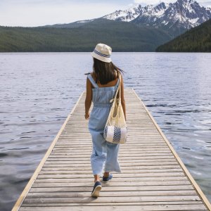 Young woman walking on dock at mountain lake