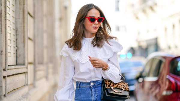 Therese Hellström wears red Celine sunglasses, a white shirt / blouse from H&M with large ruffled collar, a black leather Karl Lagerfeld bag with a chain and brown leopard print, blue denim flared jeans from Zara, on September 15, 2020 in Paris, France.