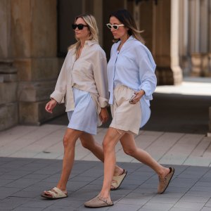 Anne Philine (L) seen wearing black Celine sunglasses, a creme beige shirt from SohoStudios, light blue SohoStudios shorts and creme white suede Birkenstock Arizona sandals; Elise Seitz (R) seen wearing white Celine sunglasses, a light blue SohoStudios shirt, a creme beige shorts from SohoStudios and beige suede Birkenstock Boston sandals, on August 16, 2022 in Hamburg, Germany.