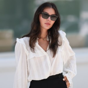 Milena Karl is seen wearing black sunglasses from Chanel, earrings from Bottega Veneta, a gold necklace, a a white shirt with puffy sleeves, black shorts from Chloe, gold and silver rings on August 22, 2023 in Hamburg, Germany.