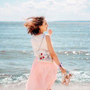 Young pretty woman with blowing skirt, pastel colors: pink and blue