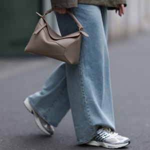DUESSELDORF, GERMANY - MARCH 14: Maria Barteczko seen wearing g-lab olive green hooded waterproof parka jacket, The Frankie Shop blue denim used baggy jeans, LOEWE beige leather big Puzzle bag and Nike light khaki Pegasus sneaker with metallic details, on March 14, 2025 in Duesseldorf, Germany. (Photo by Jeremy Moeller/Getty Images)
