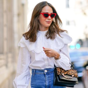 PARIS, FRANCE - SEPTEMBER 15: Therese Hellström wears red Celine sunglasses, a white shirt / blouse from H&M with large ruffled collar, a black leather Karl Lagerfeld bag with a chain and brown leopard print, blue denim flared jeans from Zara, on September 15, 2020 in Paris, France. (Photo by Edward Berthelot/Getty Images)