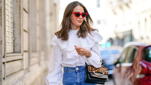 PARIS, FRANCE - SEPTEMBER 15: Therese Hellström wears red Celine sunglasses, a white shirt / blouse from H&M with large ruffled collar, a black leather Karl Lagerfeld bag with a chain and brown leopard print, blue denim flared jeans from Zara, on September 15, 2020 in Paris, France. (Photo by Edward Berthelot/Getty Images)