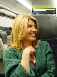 Two people smile on a train in 'Best Interests.'