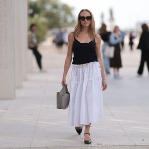 PARIS, FRANCE - SEPTEMBER 28: Guest is seen outside Chloe show wearing black sunnies, black tank top, white ruffled long skirt, taupe colored handbag and black leather ballet flats during the Womenswear Spring/Summer 2024 as part of Paris Fashion Week on September 28, 2023 in Paris, France. (Photo by Jeremy Moeller/Getty Images)