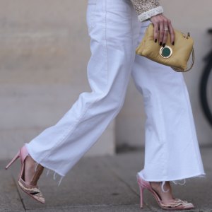 PARIS, FRANCE - SEPTEMBER 29: A guest seen wearing a beige/white jacket with silver button details, a straight leg white pants, a yellow bag and rose pointed shoes with white details, outside the Giambattista Valli Show during the Womenswear Spring/Summer 2024 as part of Paris Fashion Week on September 29, 2023 in Paris, France. (Photo by Jeremy Moeller/Getty Images)