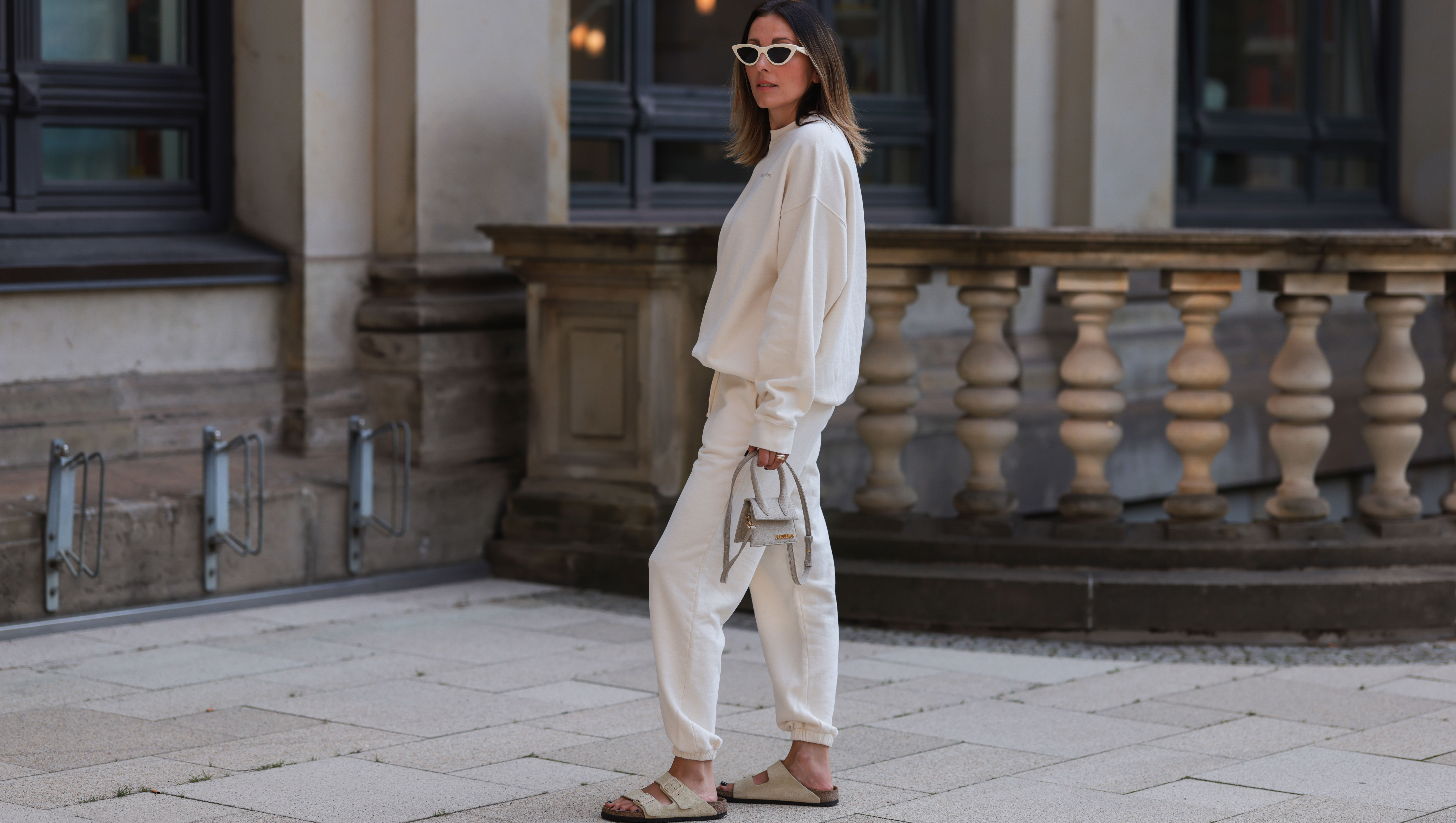 HAMBURG, GERMANY - AUGUST 16: Elise Seitz seen wearing white sunglasses from Celine, a creme white SohoStudios sweater, a creme white SohoStudios jogger pants, creme white linen Jacquemus Chiquito bag and beige suede Birkenstock Arizona sandals, on August 16, 2022 in Hamburg, Germany. (Photo by Jeremy Moeller/Getty Images)