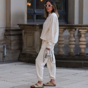 HAMBURG, GERMANY - AUGUST 16: Elise Seitz seen wearing white sunglasses from Celine, a creme white SohoStudios sweater, a creme white SohoStudios jogger pants, creme white linen Jacquemus Chiquito bag and beige suede Birkenstock Arizona sandals, on August 16, 2022 in Hamburg, Germany. (Photo by Jeremy Moeller/Getty Images)