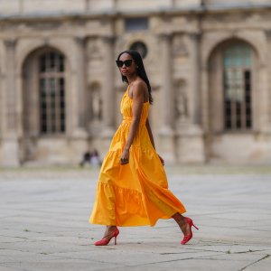 Emilie Joseph @in_fashionwetrust wears a yellow asymmetric cut-out midi dress from Mango, red mesh toe-cap strappy pumps heels shoes from Bottega Veneta, a gold ring, on June 05, 2021 in Paris, France.