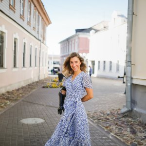 beautiful young slim woman in summer blue dress dance and walks through small town, local tourism