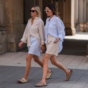Anne Philine (L) seen wearing black Celine sunglasses, a creme beige shirt from SohoStudios, light blue SohoStudios shorts and creme white suede Birkenstock Arizona sandals; Elise Seitz (R) seen wearing white Celine sunglasses, a light blue SohoStudios shirt, a creme beige shorts from SohoStudios and beige suede Birkenstock Boston sandals, on August 16, 2022 in Hamburg, Germany.