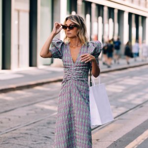 An attractive Caucasian shopaholic with a paper bag going shopping while being on vacation.
