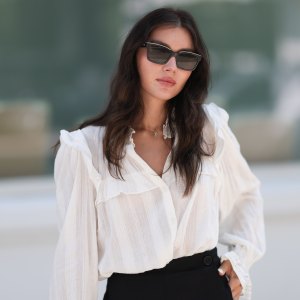 Milena Karl is seen wearing black sunglasses from Chanel, earrings from Bottega Veneta, a gold necklace, a a white shirt with puffy sleeves, black shorts from Chloe, gold and silver rings on August 22, 2023 in Hamburg, Germany.