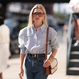 Fashion Week Guest seen wearing a white and darkblue blouse, denim blue jeans, black heels, white and brown Celine handbag, sunglasses and a black YSL belt outside Brandon Maxwell show during New York Fashion Week on September 06, 2024 in New York City.