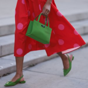 NEW YORK, NEW YORK - FEBRUARY 10: Olivia Joan seen wearing Kate Spade knit green top and cardigan, Kate Spade red long skirt with pink polka dot pattern, Kate Spate green leather bag and green leather mules before the Kate Spade presentation on February 10, 2023 in New York City. (Photo by Jeremy Moeller/Getty Images)