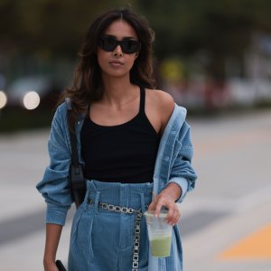 MIAMI, FLORIDA - DECEMBER 08: Paris Solati seen wearing black sunglasses, black cotton tanktop, blue corduroy two-piece / blue corduroy shirt jacket, matching blue corduroy long pants, silver chain belt, black leather shoulder bag, on December 08, 2023 in Miami, Florida. (Photo by Jeremy Moeller/Getty Images)