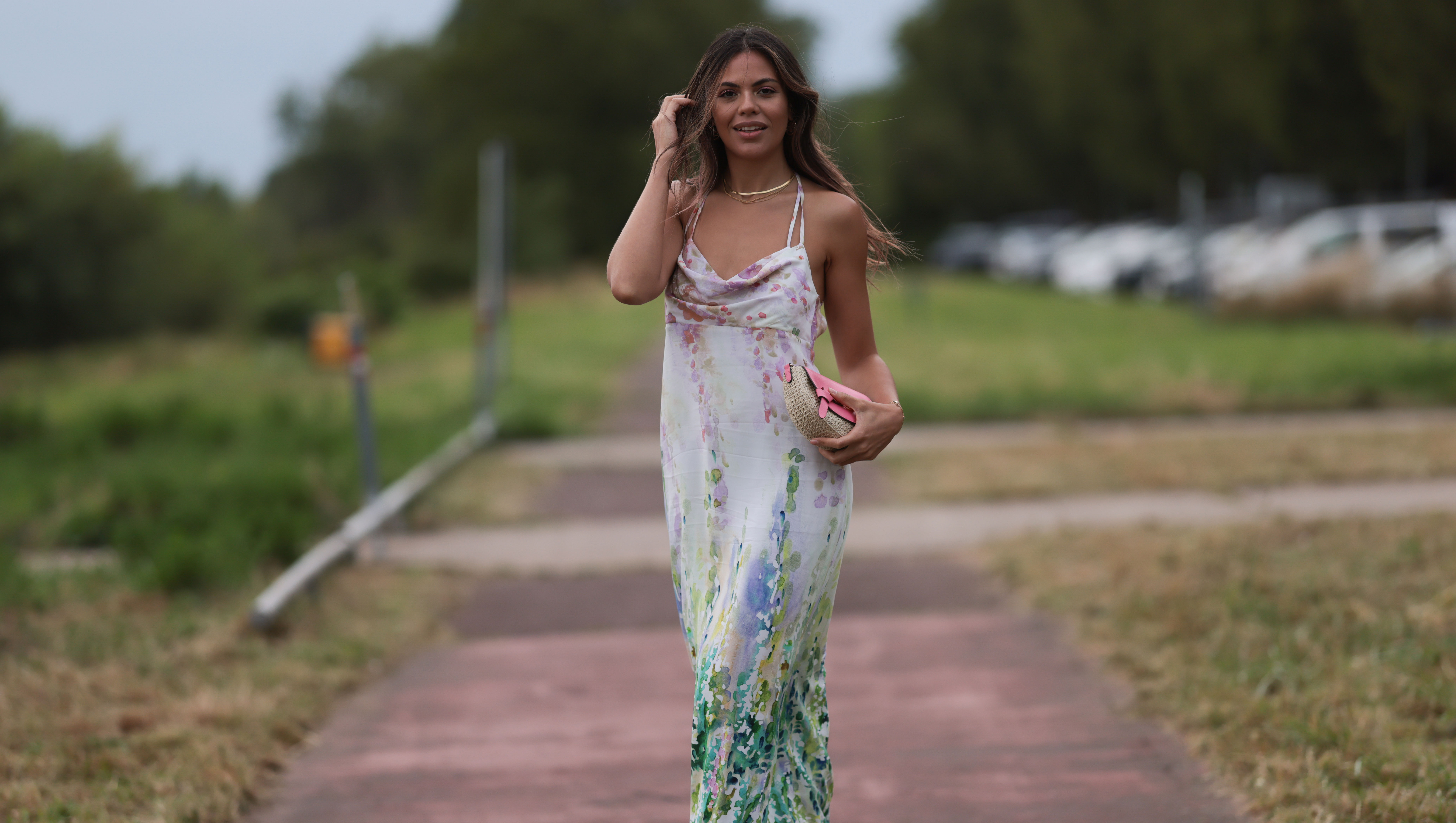 DUSSELDORF, GERMANY - JULY 22: Bruna Rodrigues is seen wearing a pastel coloured midi dress with watercolour print from Riani, a pink bag and pink strap sandals outside during the Riani Cruise 2023 on July 22, 2023 in Dusseldorf, Germany. (Photo by Jeremy Moeller/Getty Images)