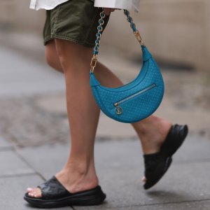 BERLIN, GERMANY - JUNE 28: Sonia Lyson wearing Louis Vuitton rubber black logo monogram sandals, white Storets oversized buttoned long sleeve flannel, Zara khaki capri pants, Louis Vuitton blue half moon monogram bag and black gold logo shades on June 28, 2023 in Berlin, Germany. (Photo by Jeremy Moeller/Getty Images)