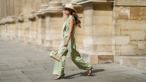PARIS, FRANCE - MAY 29: Angela Gonzalez wears a beige suede Lack Of Color hat, earrings, a black off shoulder top, a pale green buttoned blazer jacket sleeveless from Nasty Gal, pale green matching Nasty Gal flared pants, a gold chain bracelet, a beige shiny leather Mango handbag, brown shiny leather strappy hells Na-Kd sandals, on May 29, 2021 in Paris, France. (Photo by Edward Berthelot/Getty Images)