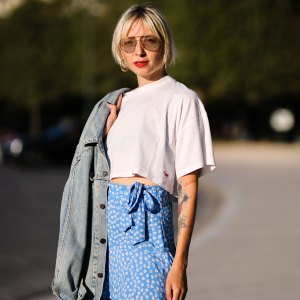 PARIS, FRANCE - AUGUST 25: Emy venturini wears sunglasses from Prada, gold large earrings, a white cropped t-shirt from Ipsilon, a blue faded denim oversized long jacket, a blue with daisy flower print pattern flowing / high waist / knotted / short skirt from Zara, gold rings, on August 25, 2021 in Paris, France. (Photo by Edward Berthelot/Getty Images)