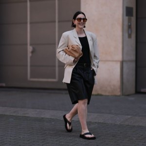 DUSSELDORF, GERMANY - MAY 28: Maria Barteczko wearing Oversized Studio light beige cut out blazer, ARKET black top, Zara black belted leather culottes trousers, Mango beige leather pouch, The Row black plateau flip flops, Celine gold earrings and Spitfire orange black framed sunglasses on May 28, 2023 in Dusseldorf, Germany. (Photo by Jeremy Moeller/Getty Images)