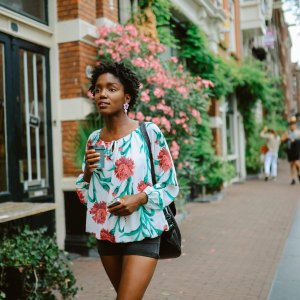 Amsterdam city lifestyle. Young woman walks the streets, casually exploring the city or going to meet her friends for a coffee. Travel and urban lifestyle concepts.