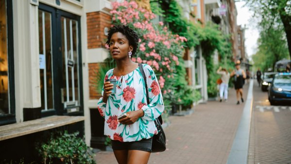 Amsterdam city lifestyle. Young woman walks the streets, casually exploring the city or going to meet her friends for a coffee. Travel and urban lifestyle concepts.