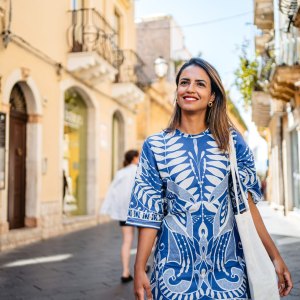 Beautiful young Brazilian woman walking on town square in Taormina in Sicily.