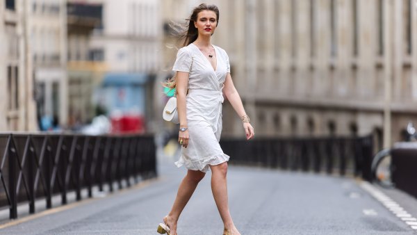 Fashion blogger @hippolyt.e wears a white lace with belted short ruffled dress from Nach Bijoux, rings and necklace from Nach Bijoux, a gold Chanel bracelet, a white matter leather shoulder bag from Charlie Paris, a silver and black Chanel watch, golden shoes, on May 20, 2021 in Paris, France.