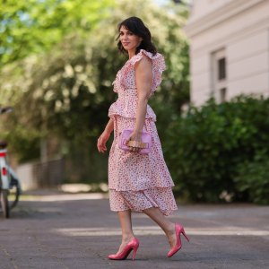 Anna Wolfers wearing white and pink ruffle dress via Goldig Shop, pink Moschino clutch and pink heels on May 31, 2021 in Hamburg, Germany.