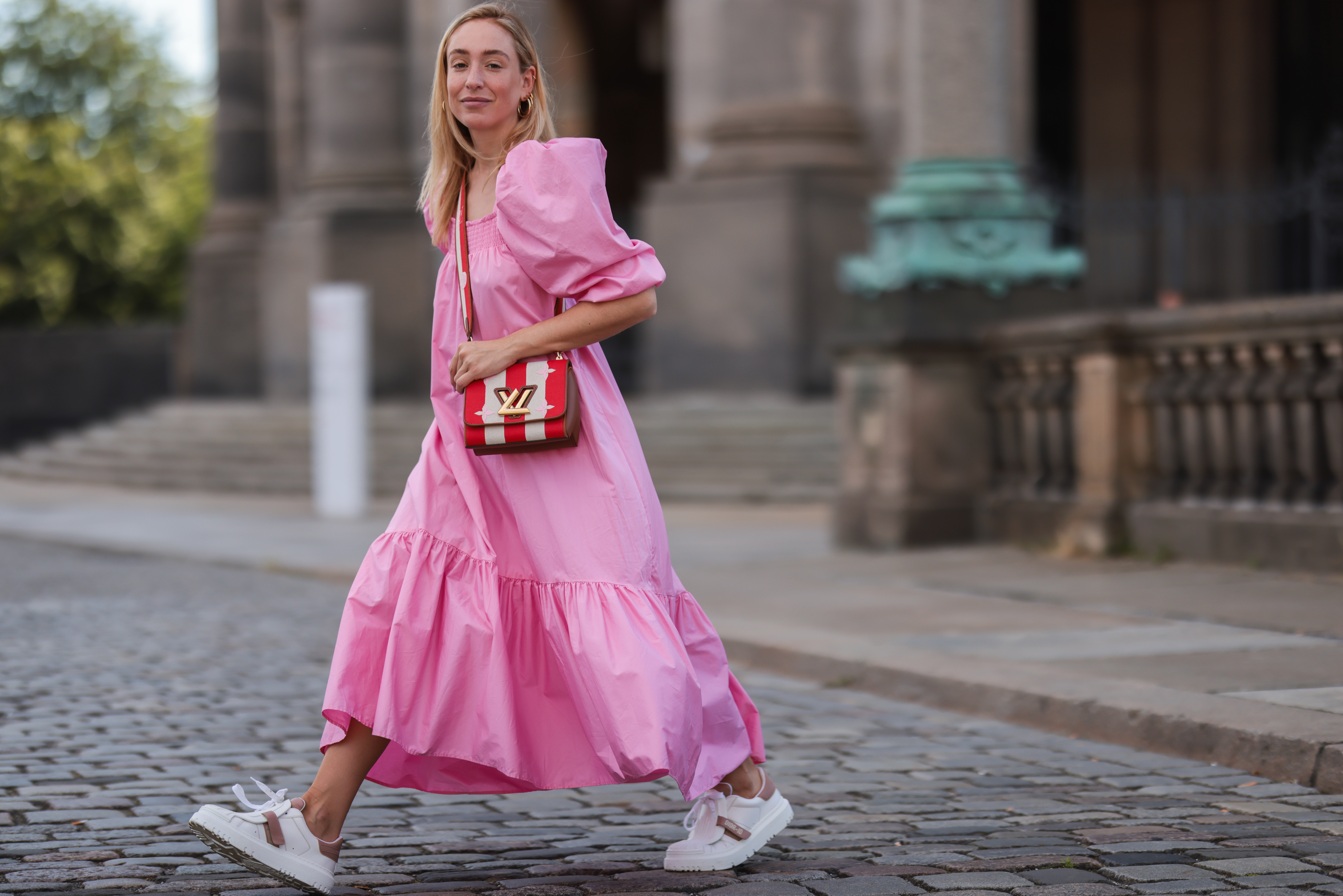 Sonia Lyson wearing Louis Vuitton bag, white Dior ID sneakers and pink H&M maxi dress on July 06, 2021 in Berlin, Germany.