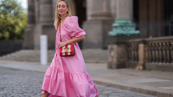 Sonia Lyson wearing Louis Vuitton bag, white Dior ID sneakers and pink H&M maxi dress on July 06, 2021 in Berlin, Germany.