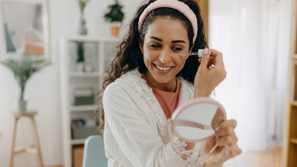One brunette applying face serum to make her face beautiful