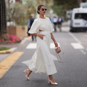 Jessica de Oliviera seen wearing Dior black sunglasses, Dior bag, Chanel heels, Rolex yellow gold watch and a flowy long dress with cutouts during the 76th Cannes film festival on May 21, 2023 in Cannes, France.