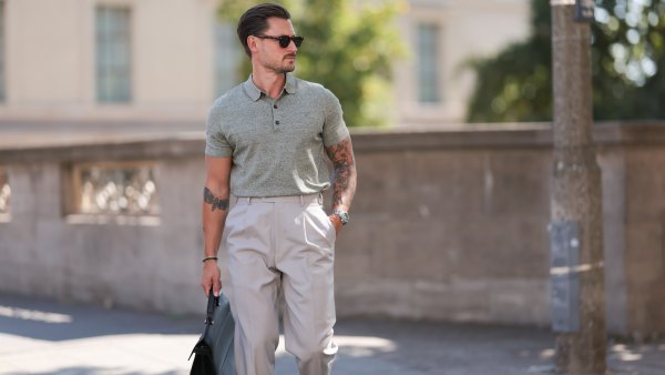 André Hellmundt seen wearing Explicit Poets brown sunglasses, Barbour sage green knit polo shirt, Suit Supply beige long suit pants, Tagheuer silver watch, Furla black leather briefcase / business bag and Bobbie’s Paris brown leather loafers, on August 27, 2024 in Berlin, Germany.