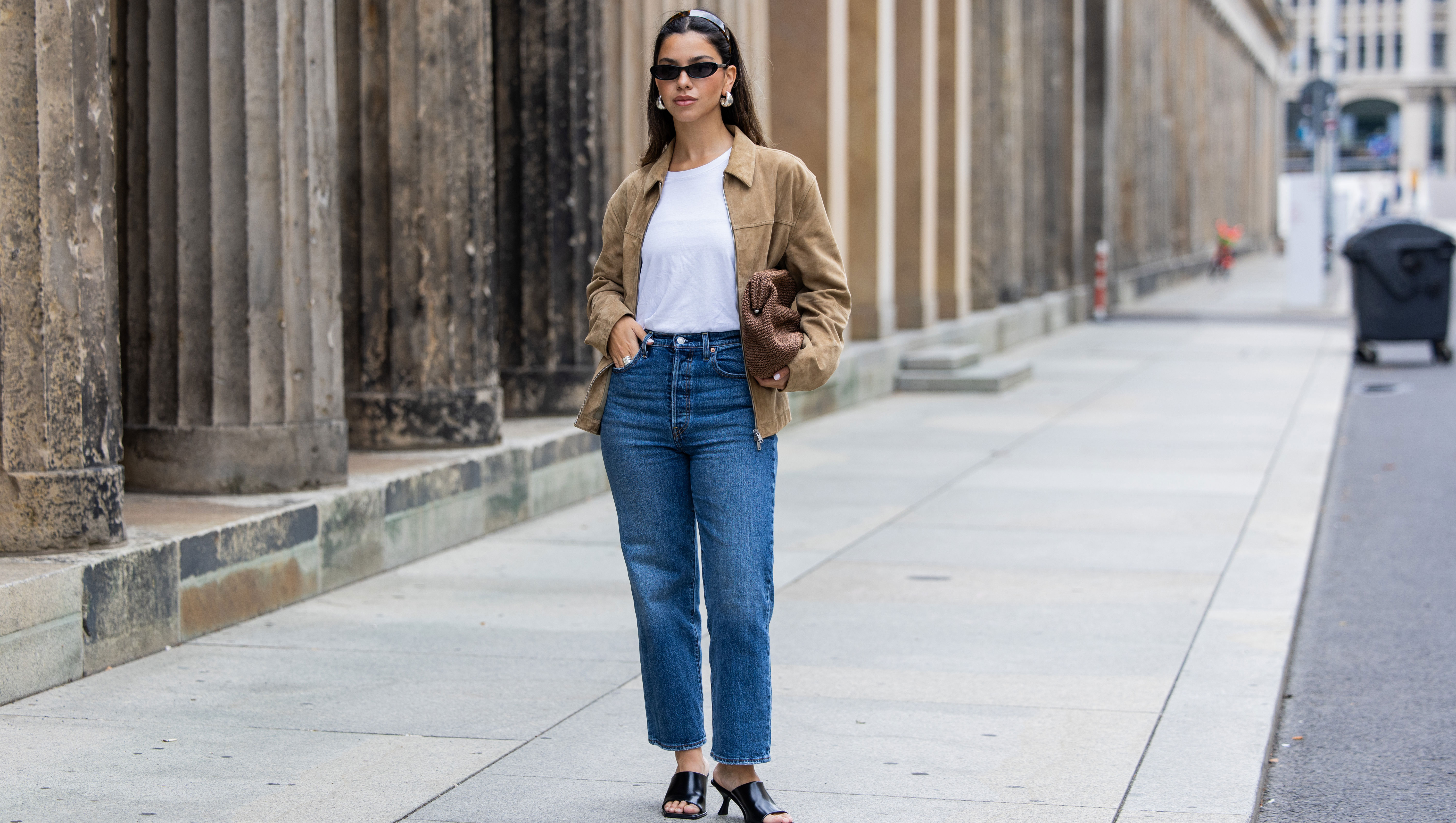 BERLIN, GERMANY - JULY 01: Bella Emar wears Levi’s blue denim jeans, white Cos t-shirt, brown Massimo Dutti Jacket, black H&M Heels, Mango sunglasses during the Berlin Fashion Week SS25 on July 01, 2024 in Berlin, Germany. (Photo by Christian Vierig/Getty Images)