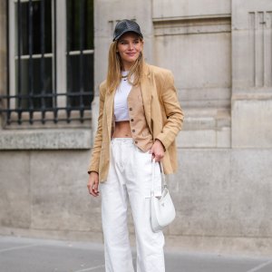 PARIS, FRANCE - MAY 16: Natalia Verza @mascarada.paris wears, a black leather cap, a beige linen oversized blazer jacket from Aeron, a white cropped t-shirt, white ripped denim jeans pants, a white Prada Cleo bag, high heels pointed pumps shoes from Louboutin, on May 16, 2021 in Paris, France. (Photo by Edward Berthelot/Getty Images)