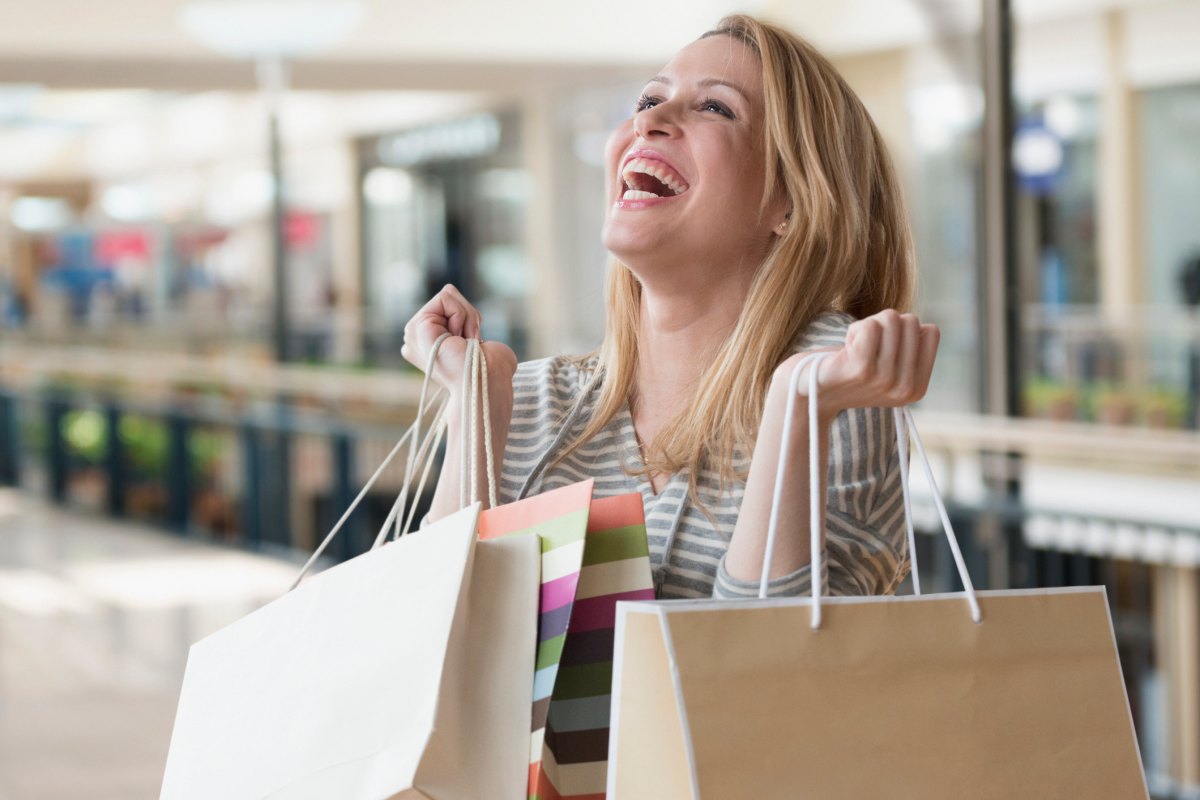 Mixed race woman carrying shopping bags in mall