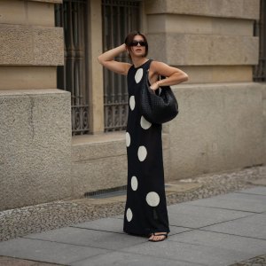 BERLIN, GERMANY - JUNE 24: Sophia Geiss is seen wearing a black and white long sleeveless polka dot knit dress with round neckline from Zara; a black Nana leather hobo bag with braided structure from abro; black PR 25YS sunglasses with rectangular biker shape from Prada; a pair of black thong sandals with kitten heel from LeGer by Lena Gercke; a pair of silver Harmonie big hoop earrings from black palms the label; a thin gold bangle from Daniel Wellington on June 24, 2025 in Berlin, Germany. (Photo by Moritz Scholz/Getty Images)