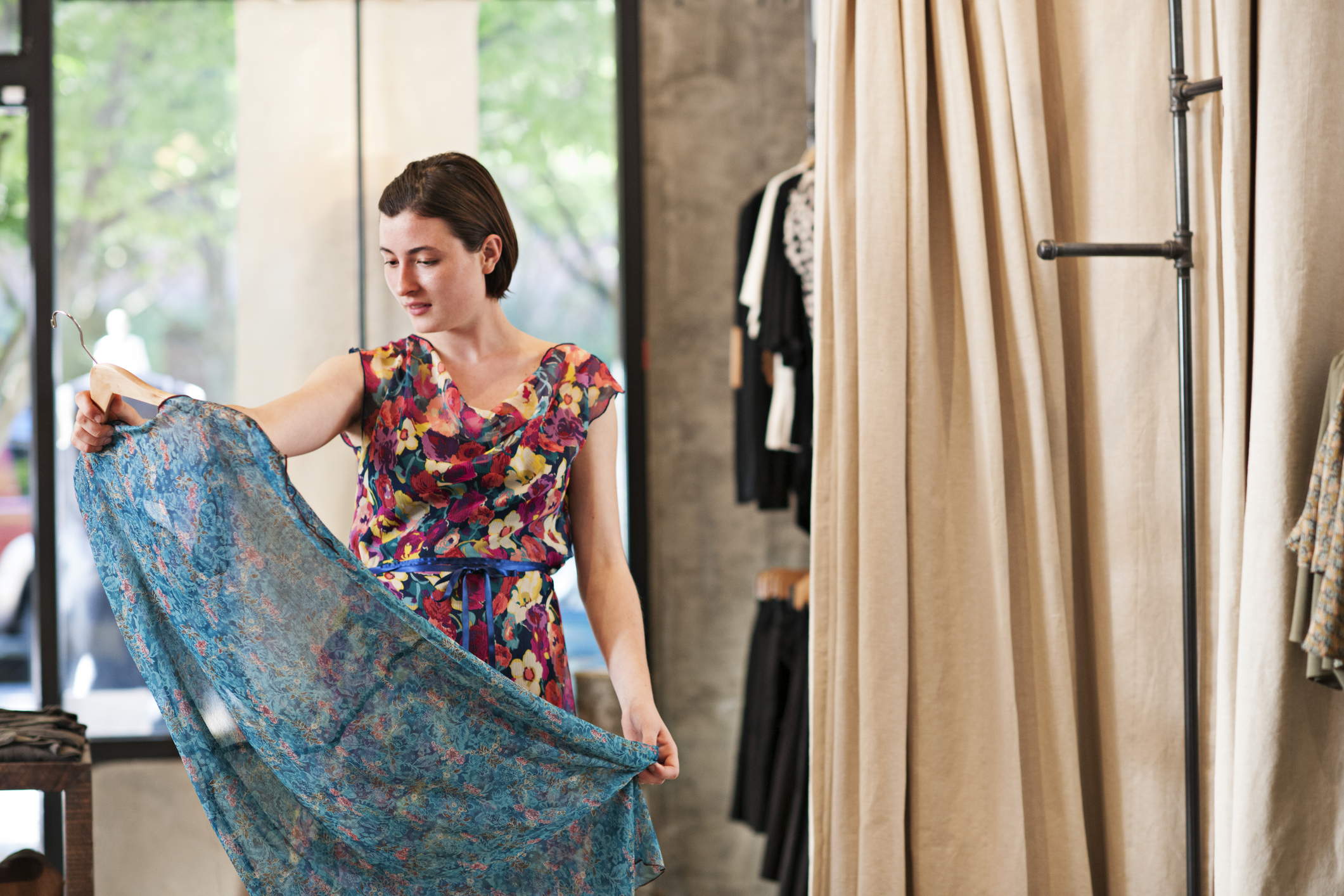Woman in a floral dress admires another floral dress